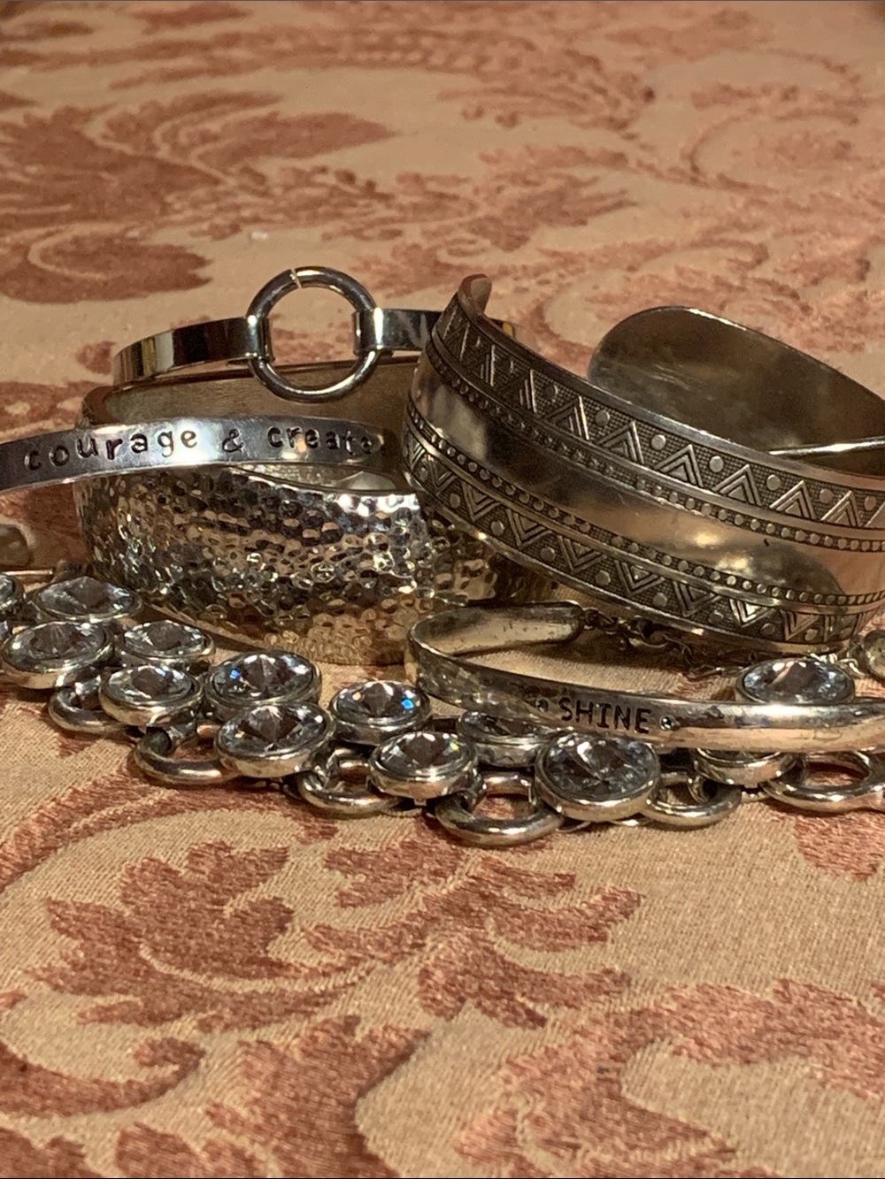 A collection of silver tone bracelets
